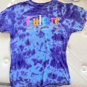 Purple and blue tie dye shirt that reads “Culture” with a bunch of big cities.